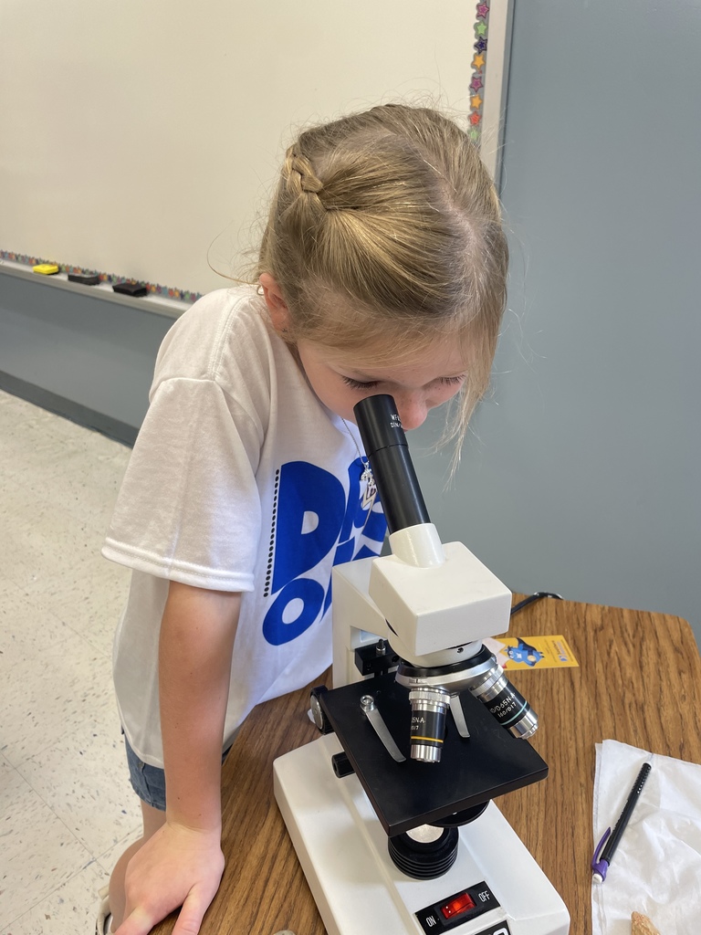 female student using a microscope