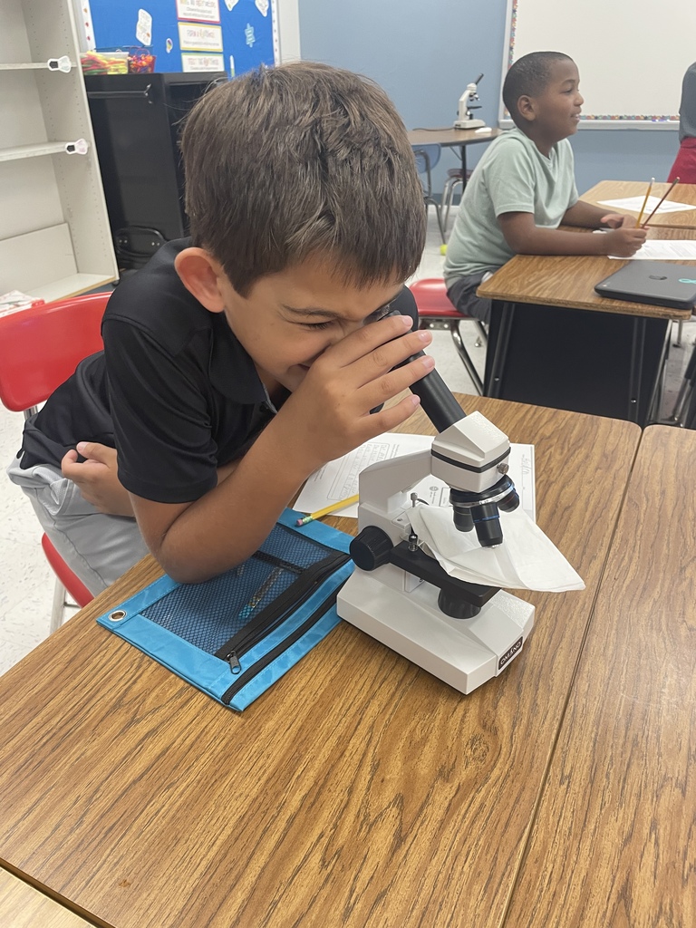 male student using a microscope