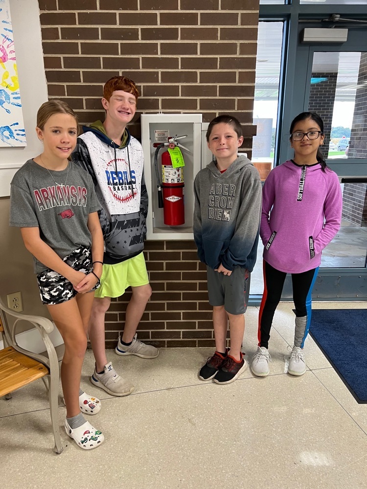 DES Fire Marshals - 4 students standing by the fire extinguisher 